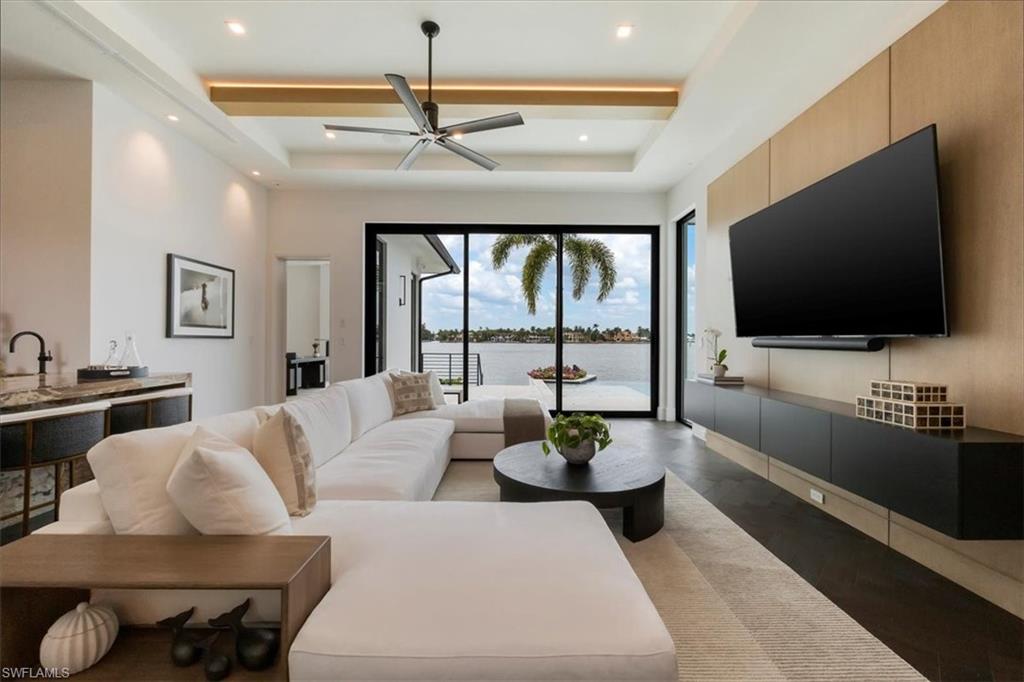 1640 Dolphin Court Naples, FL 34102 - Photo 11 of 45 a living room with furniture and a flat screen tv