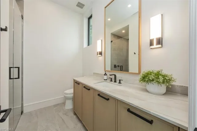 a bathroom with a granite countertop sink a mirror and vanity