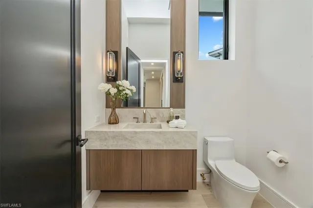 a bathroom with a granite countertop toilet sink and mirror