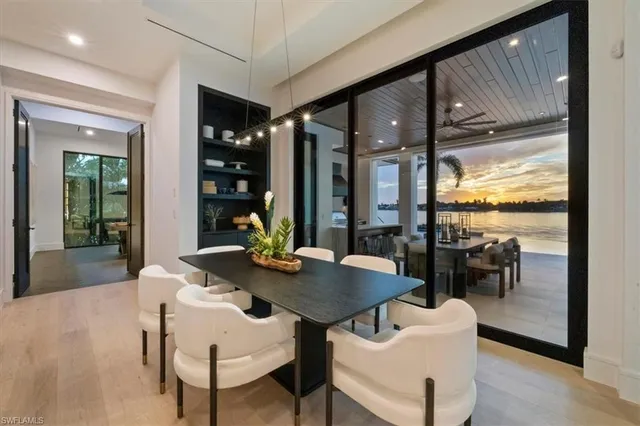 a view of a dining room with furniture wooden floor and floor to ceiling window
