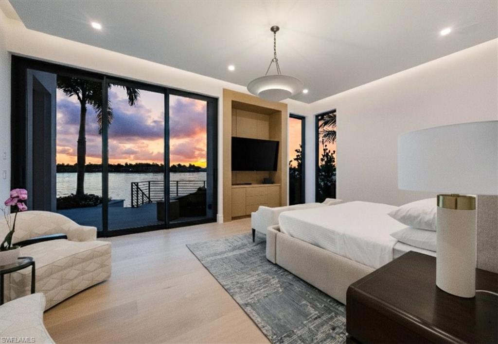 1640 Dolphin Court Naples, FL 34102 - Photo 20 of 45 a bedroom with a large bed and a flat tv screen