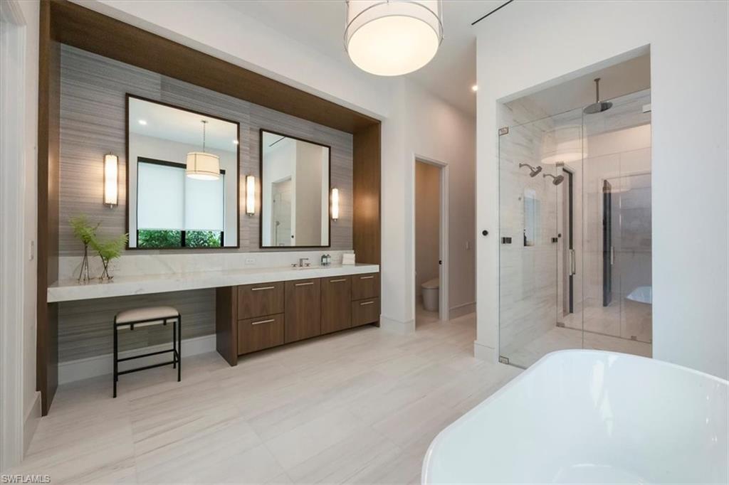 1640 Dolphin Court Naples, FL 34102 - Photo 23 of 45 a bathroom with a sink mirror and a bathtub