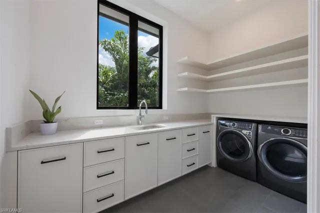 a utility room with sink dryer and washer