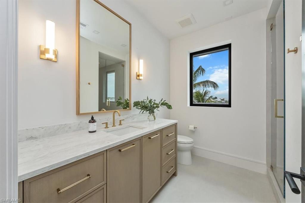 1640 Dolphin Court Naples, FL 34102 - Photo 38 of 45 a bathroom with a double vanity sink and a mirror