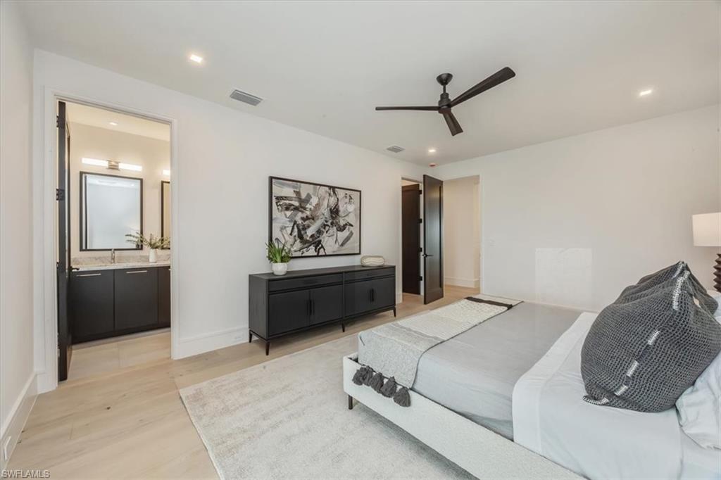 1640 Dolphin Court Naples, FL 34102 - Photo 40 of 45 a bedroom with a bed and a chandelier