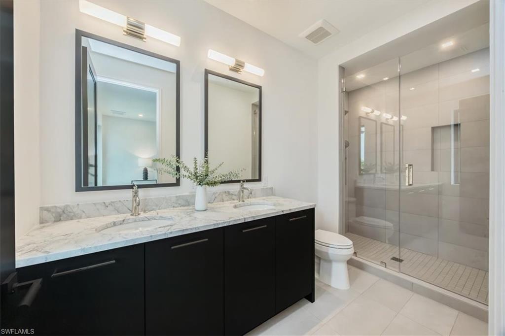1640 Dolphin Court Naples, FL 34102 - Photo 41 of 45 a bathroom with a double vanity sink mirror double shower and a bathtub