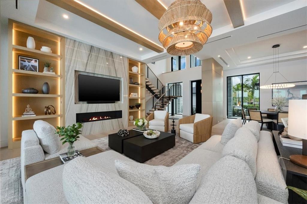 1640 Dolphin Court Naples, FL 34102 - Photo 5 of 45 a living room with furniture a flat screen tv and a chandelier