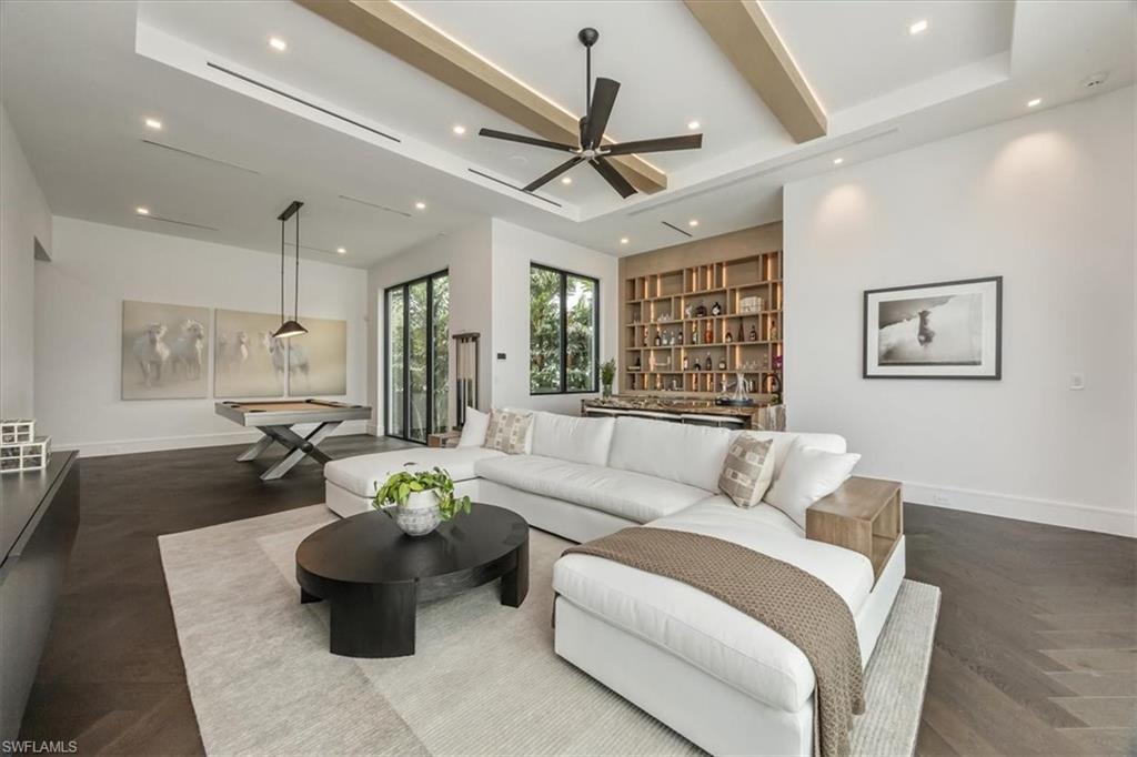 1640 Dolphin Court Naples, FL 34102 - Photo 8 of 45 a living room with furniture a ceiling fan and a chandelier