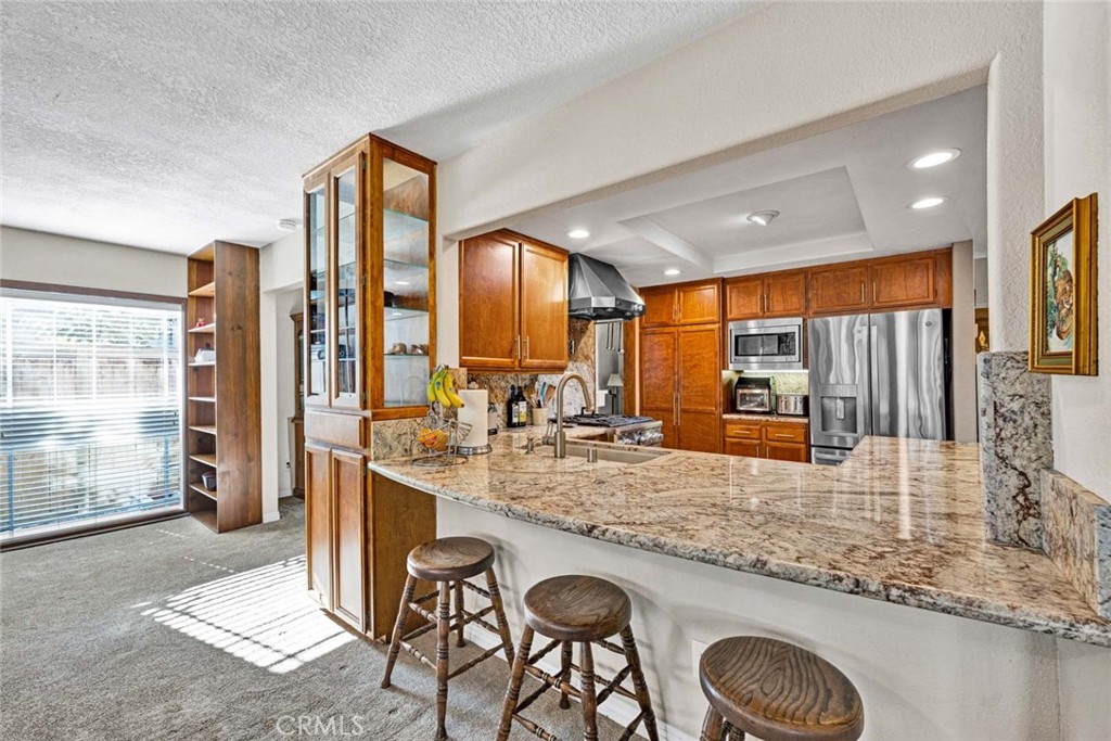 14682 Emerywood Road Tustin, CA 92780 - Photo 5 of 32 Kitchen features granite countertops, stainless steel appliances, a gas range, and rich wood cabinetry!