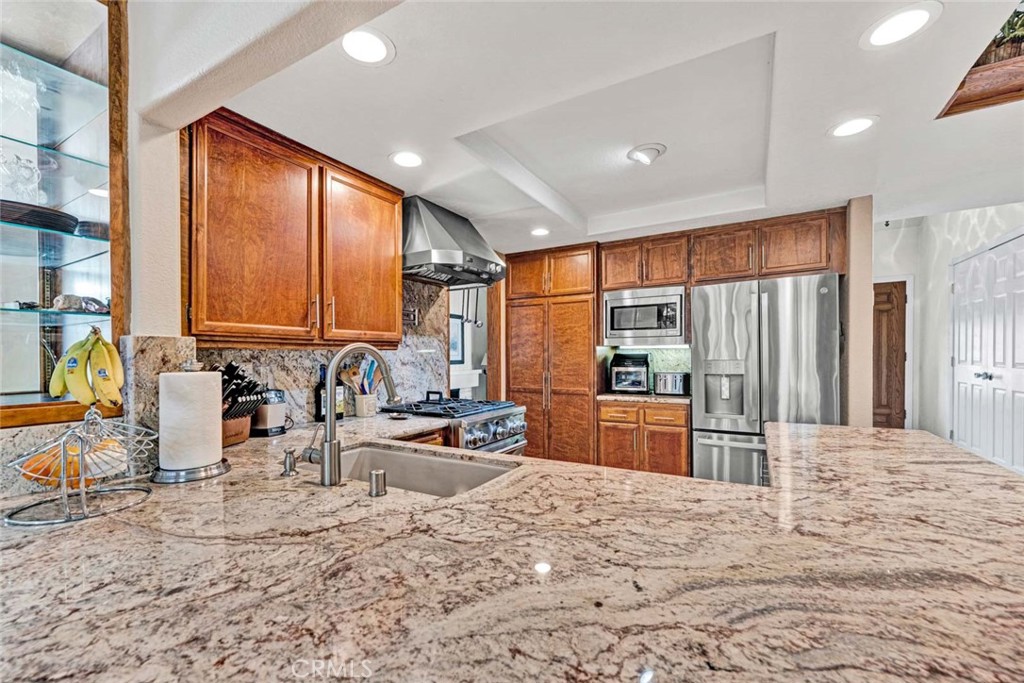 14682 Emerywood Road Tustin, CA 92780 - Photo 7 of 32 Kitchen features granite countertops, stainless steel appliances, a gas range, and rich wood cabinetry!
