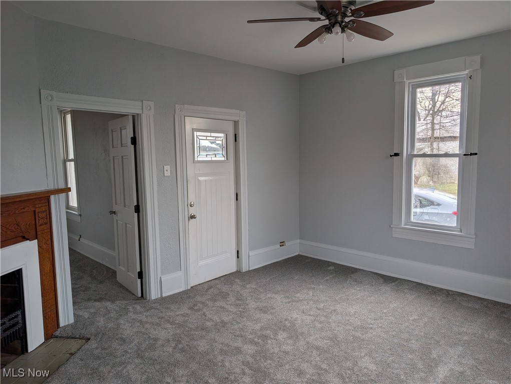 10143 Pleasant Road Pleasant City, OH 43772 - Photo 6 of 32 Foyer featuring light colored carpet, a fireplace, plenty of natural light, and a ceiling fan