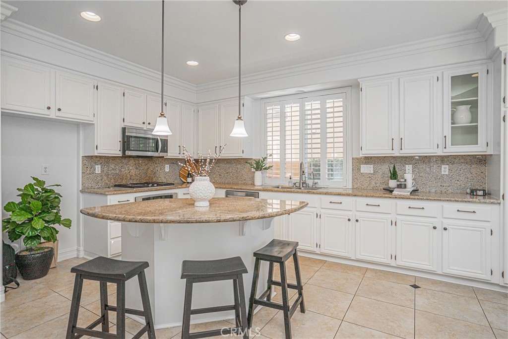 17 Mt Vernon Irvine, CA 92620 - Photo 4 of 25 a kitchen with granite countertop white cabinets and chairs