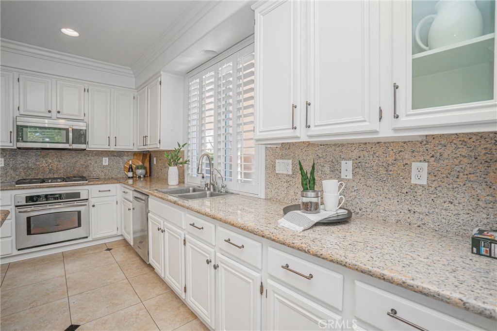17 Mt Vernon Irvine, CA 92620 - Photo 5 of 25 a kitchen with granite countertop white cabinets white appliances and sink