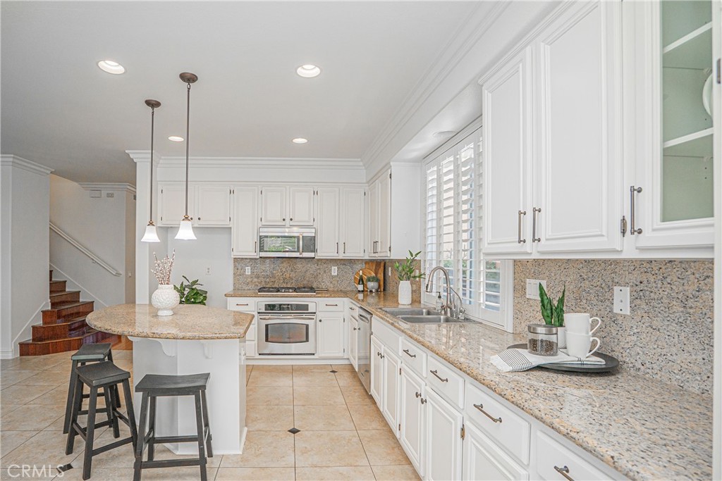 17 Mt Vernon Irvine, CA 92620 - Photo 7 of 25 a kitchen with white cabinets and stainless steel appliances