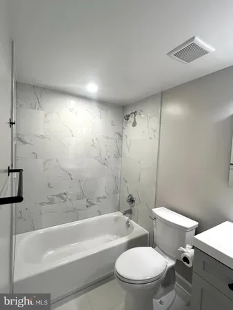a white toilet and tub sitting next to a bathroom sink