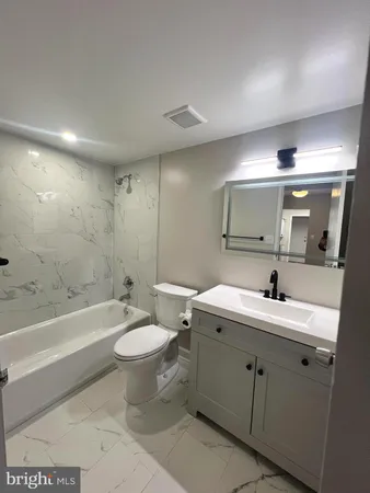 a bathroom with a double vanity sink toilet mirror and bathtub