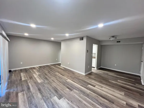a view of an empty room with wooden floor
