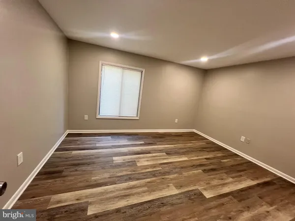 a view of a room with wooden floor and window