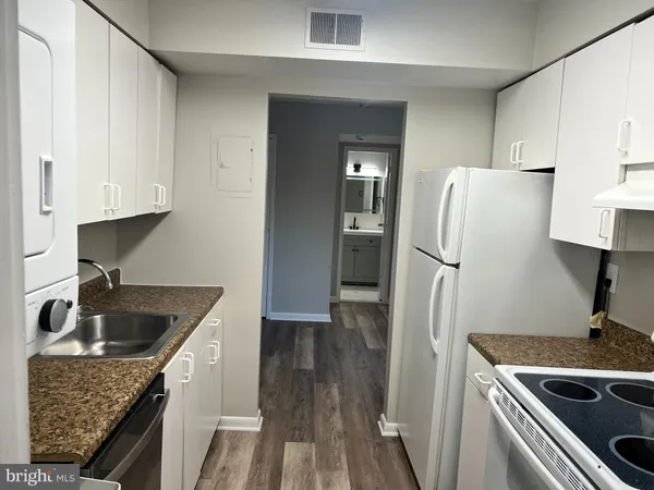 a kitchen with granite countertop a sink stove and refrigerator