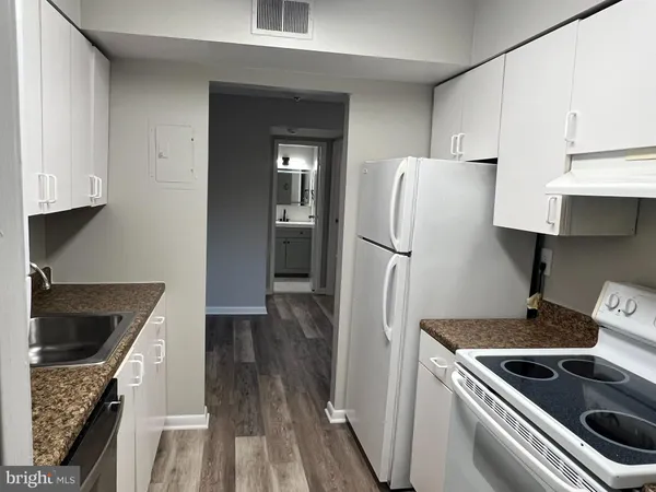 a kitchen with a refrigerator stove and cabinets