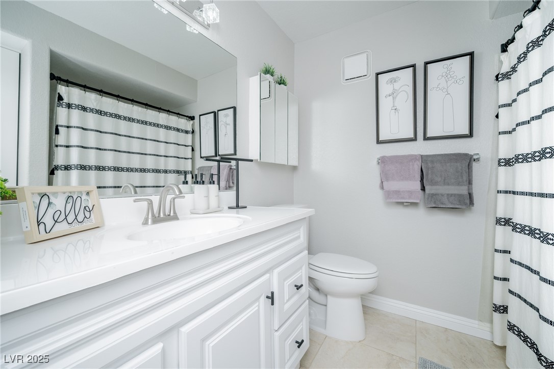 7950 West Flamingo Road, Unit 1173 Las Vegas, NV 89147 - Photo 23 of 31 Full bathroom featuring vanity, curtained shower, toilet, baseboards, and tile patterned flooring