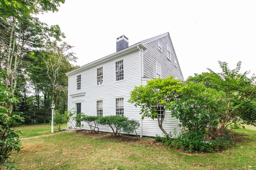 a front view of a house with a yard and potted plants