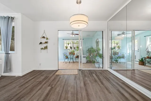 a view of a room with wooden floor potted plant and windows
