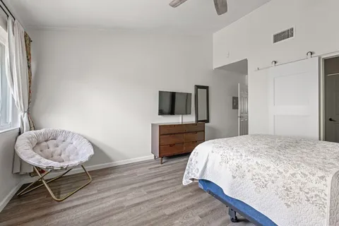 a bedroom with a bed and a flat screen tv