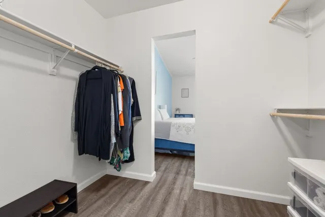 a view of walk in closet with clothes and shoes