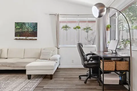 a living room with furniture a large window and a chandelier