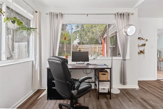 a view of a room with wooden floor potted plant and windows