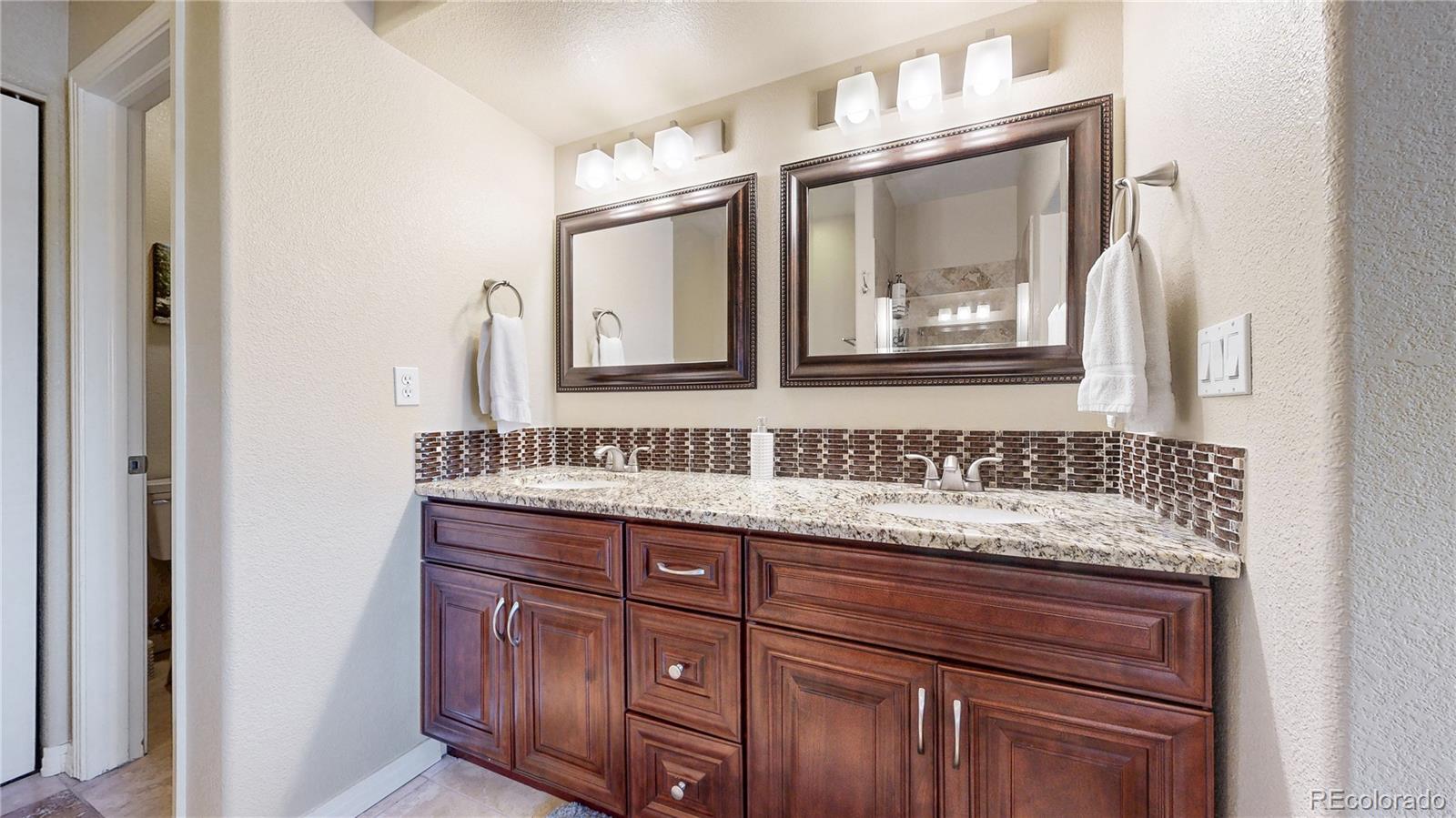 3401 West 111th Loop, Unit B Westminster, CO 80031 - Photo 14 of 40 a bathroom with a granite countertop double vanity sink and mirror