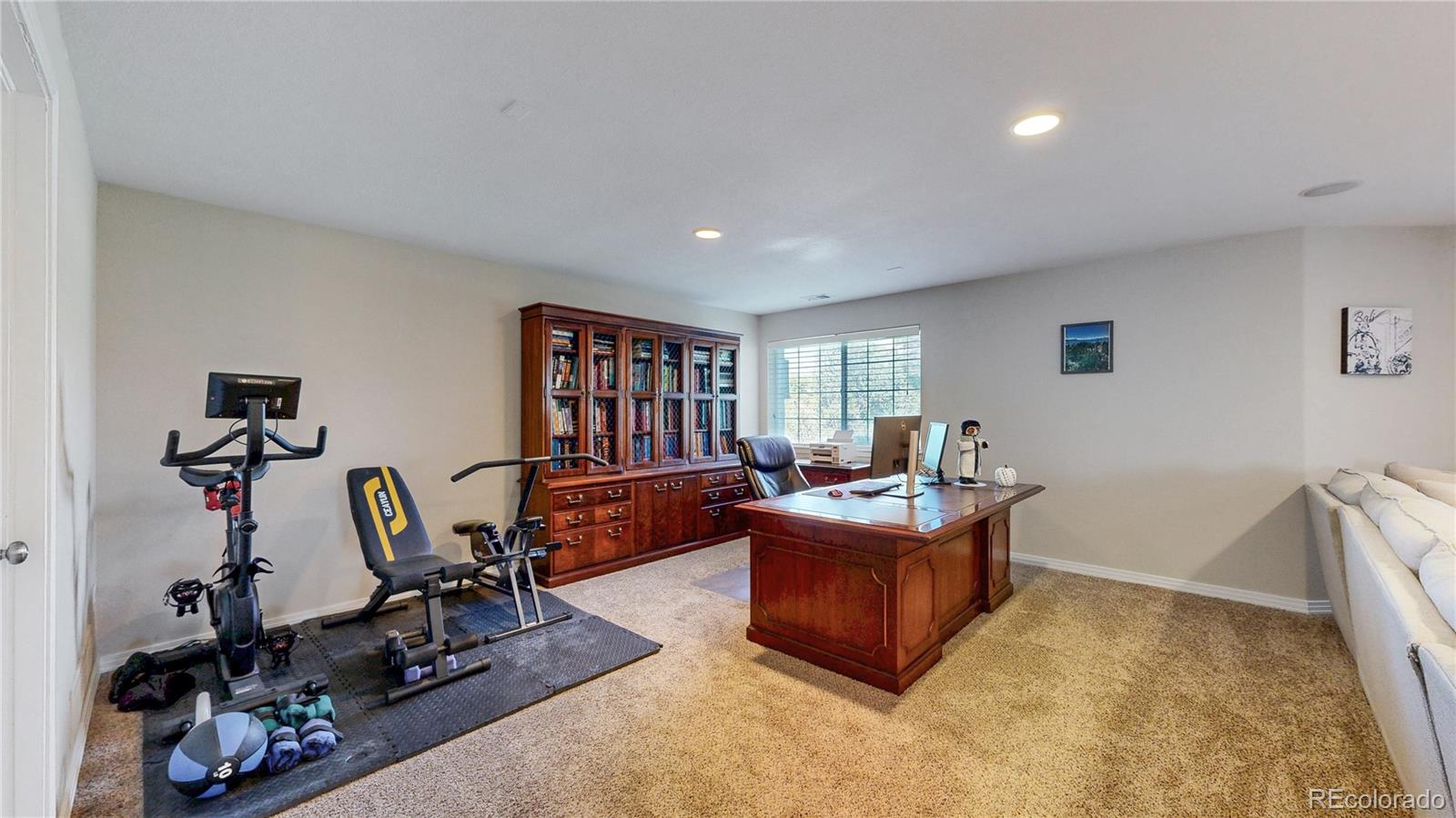 3401 West 111th Loop, Unit B Westminster, CO 80031 - Photo 24 of 40 a living room with furniture a rug and gym equipment