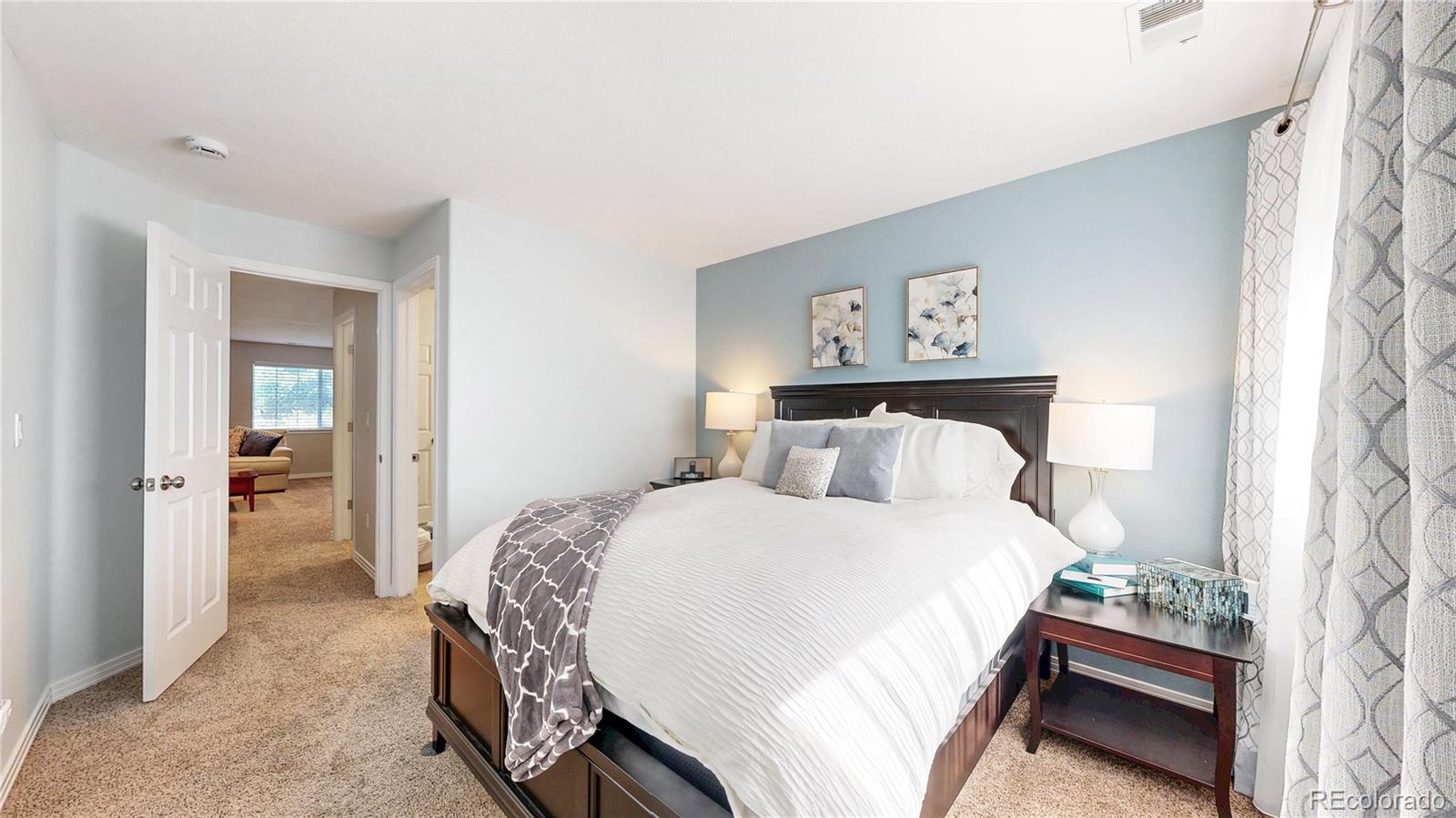 3401 West 111th Loop, Unit B Westminster, CO 80031 - Photo 26 of 40 a bedroom with a bed and a mirror