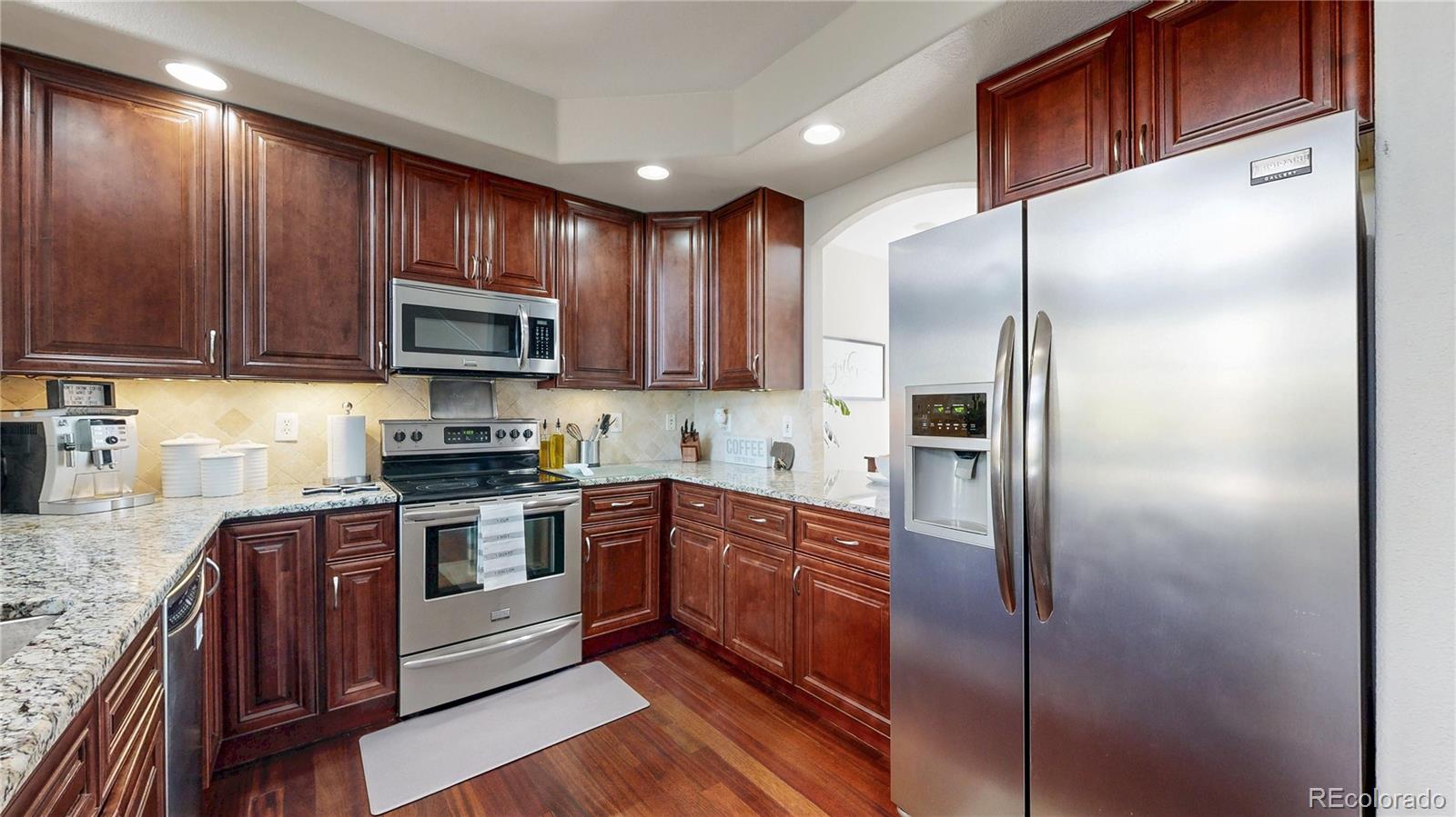 3401 West 111th Loop, Unit B Westminster, CO 80031 - Photo 5 of 40 a kitchen with stainless steel appliances granite countertop a stove a refrigerator and a microwave