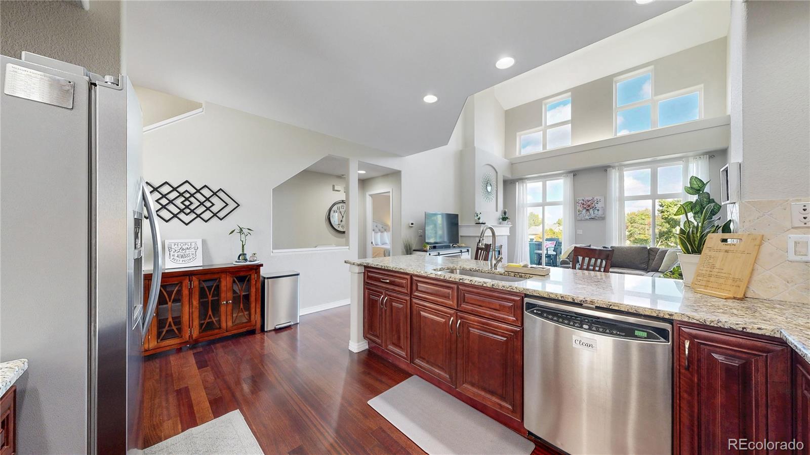 3401 West 111th Loop, Unit B Westminster, CO 80031 - Photo 6 of 40 a large kitchen with stainless steel appliances granite countertop a lot of counter space and wooden floor
