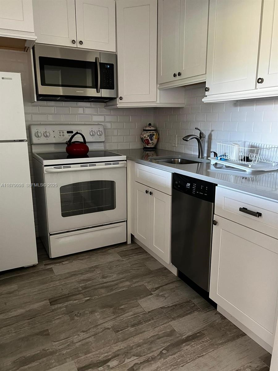22 Brighton A, Unit 22 Boca Raton, FL 33434 - Photo 10 of 12 a kitchen with stainless steel appliances granite countertop a stove a microwave and a white cabinets