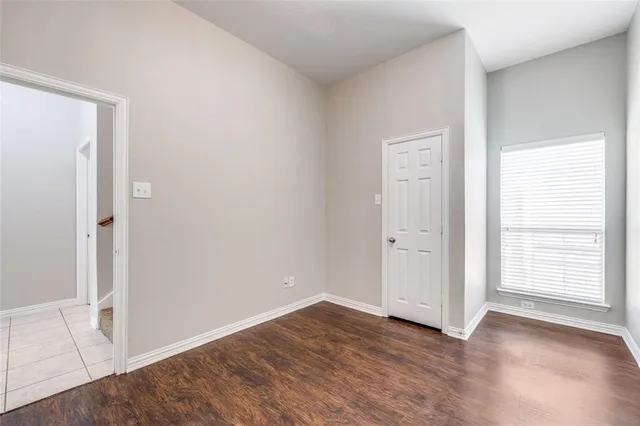 an empty room with wooden floor and window