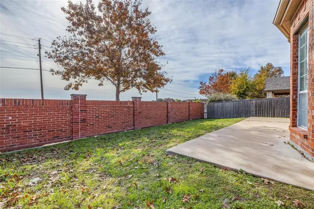 a view of backyard with wooden fence