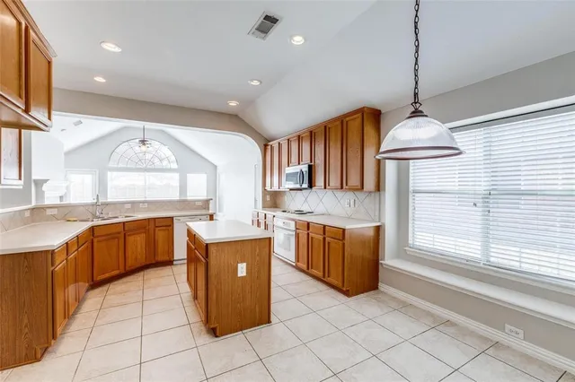 a kitchen with stainless steel appliances granite countertop a stove a sink a refrigerator and a cabinets