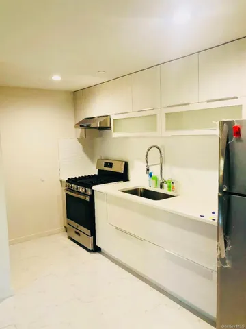 a room with a sink and a refrigerator