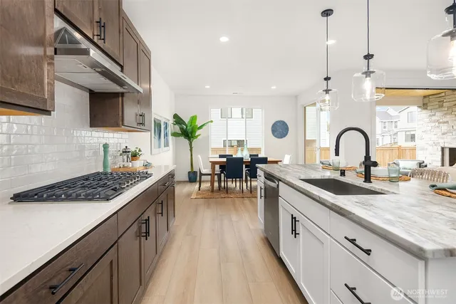 a kitchen with granite countertop a sink a counter top space and stainless steel appliances