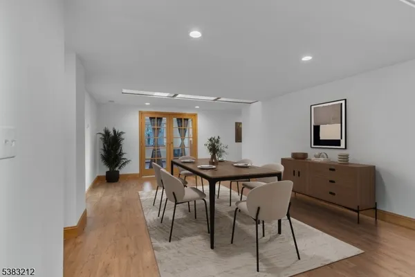 a view of an empty room with wooden floor and windows