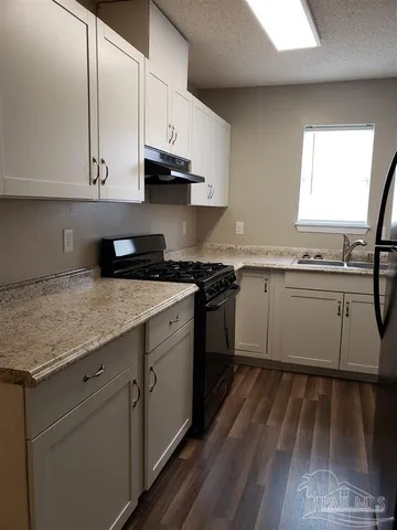 a kitchen with stainless steel appliances granite countertop a sink stove and cabinets
