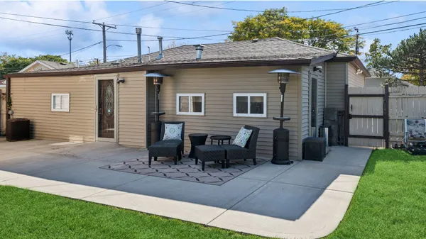 a view of a house with a yard and lawn chairs with a fire pit