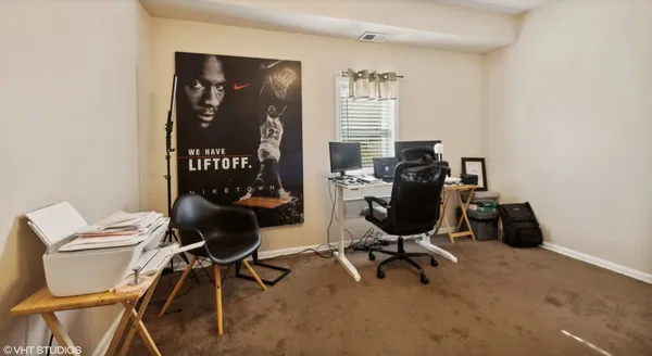 a view of a workspace with furniture and a window