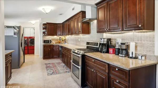 a kitchen with stainless steel appliances granite countertop a sink stove and refrigerator