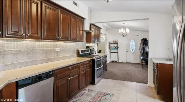 a kitchen with stainless steel appliances granite countertop a refrigerator and a sink