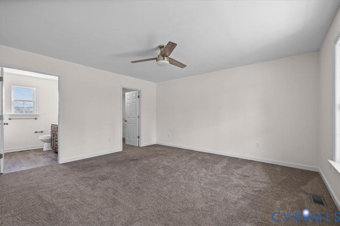 11325 Webb Road Disputanta, VA 23842 - Photo 11 of 32 an empty room with chandelier fan and windows