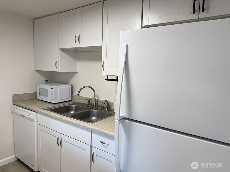 2411 South 248th Street, Unit D24 Kent, WA 98032 - Photo 9 of 21 a kitchen with a refrigerator and cabinets